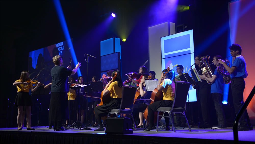 A photo of an orchestra on stage at the CBYA Gala.