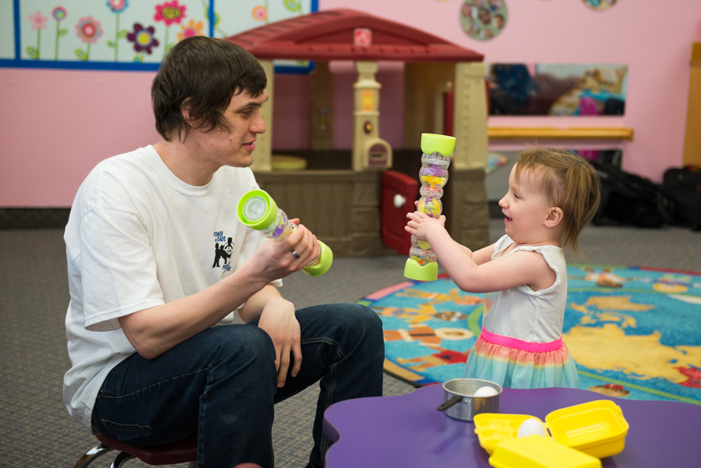 A photo of Myke playing with his daughter.