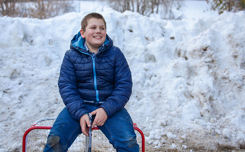 Killaloe CRC_Blog Thumb Boy sitting on top of mini hockey net, outside.