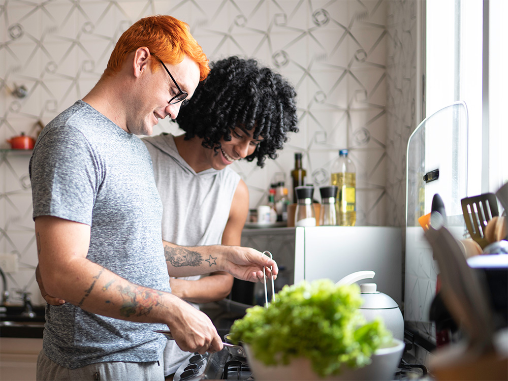 Two teens making a meal together in the kitchen.