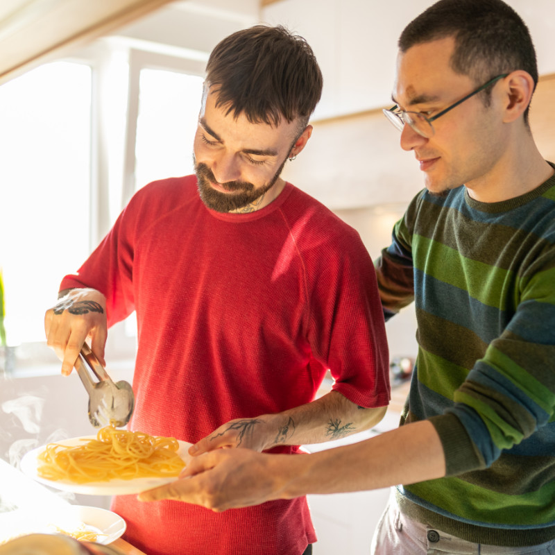 A photo of two people making a pasta dinner together in the kitchen.